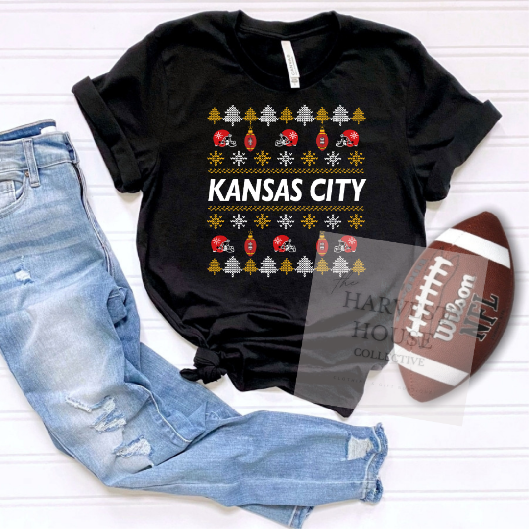Black t-shirt with 'Kansas City' design, blue jeans, and football on a white background